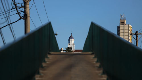 Tower amidst buildings against clear blue sky