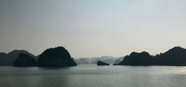 Scenic view of sea and mountains against clear sky