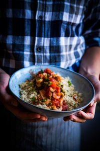 Midsection of man holding food in bowl