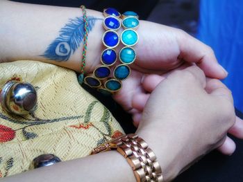 Cropped hand of woman with tattoo and bracelet