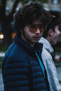 Side view portrait of young man wearing eyeglasses while walking in city