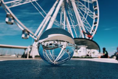 Low angle view of crystal ball against ferris wheel 