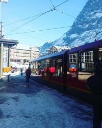 Train at railroad station in city against sky