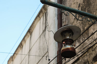 Low angle view of electric lamp against sky