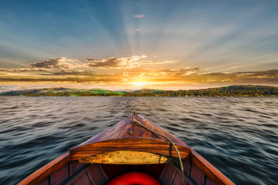 Cropped image of boat in sea at sunset