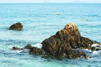 Rock formation in sea against sky