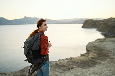 Young woman looking at sea against sky