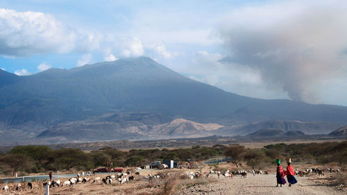 People on mountains against sky