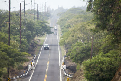 Road amidst trees against mountain