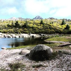 Scenic view of lake and mountains against cloudy sky