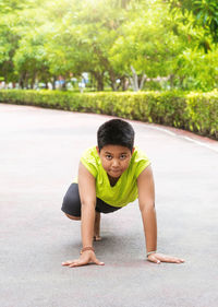 Portrait of young woman exercising on road