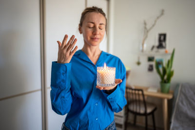 Portrait of young woman using mobile phone while sitting at home