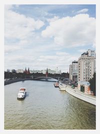 Boats in river with buildings in background