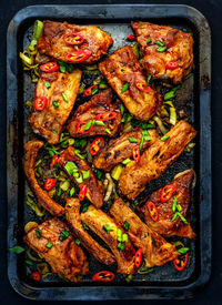 High angle view of meat in plate over black background