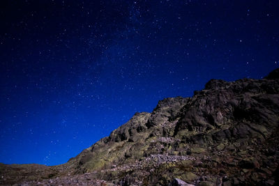 Low angle view of mountain range against blue sky