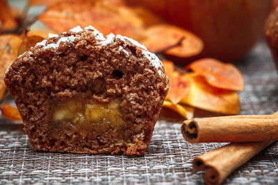 Chocolate muffins with apple filling on a background of autumn leaves and cinnamon