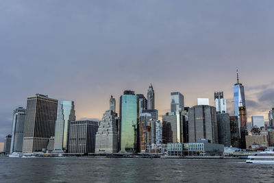 Sea by buildings against sky in city