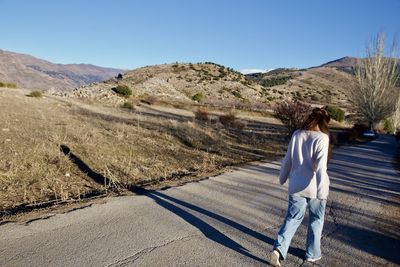 Rear view of man on road against mountain