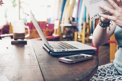 Close-up of man using laptop on table