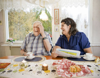 Nurse with senior man at table, sweden
