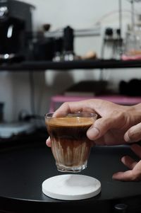 Close-up of hand holding coffee cup