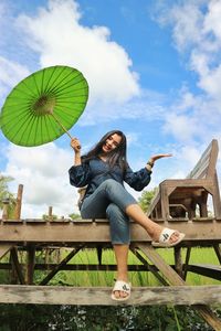 Full length of woman sitting against sky