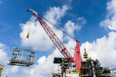 Low angle view of crane against sky
