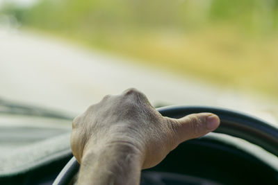 Close-up of person hand driving car