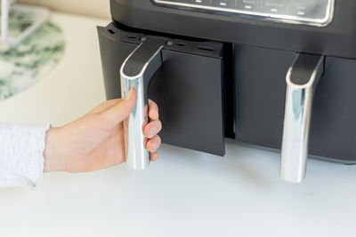 Cropped hand of person holding camera on table