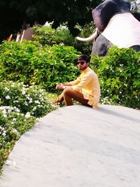 Young man sitting on plant