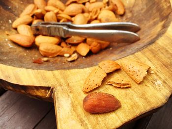Close-up of almond shells and nutcracker in bowl