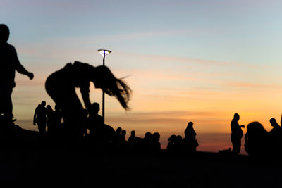 Silhouette people against sky during sunset