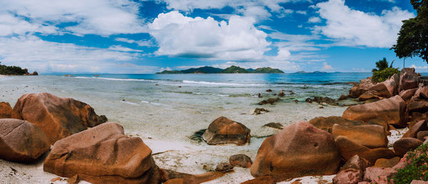 Panoramic shot of rocks on beach against sky