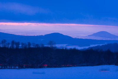 Scenic view of landscape against sky during winter