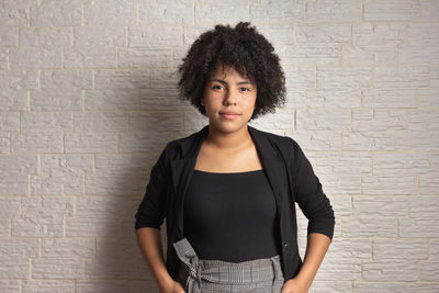 Portrait of woman standing against wall