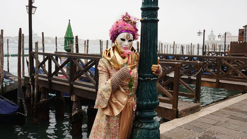 Portrait of young woman standing on bridge in city