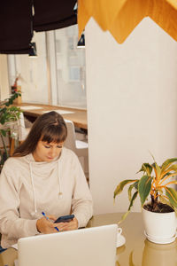 Side view of boy using digital tablet while sitting at home