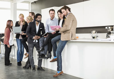Group of multi-ethnic business people communicating at counter in office