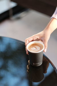 Cropped hand of woman holding coffee