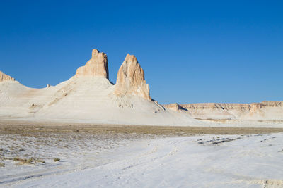 Scenic view of snowcapped mountains against clear blue sky