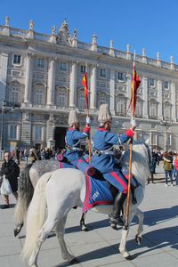 Two royal guards crossing by horse the oriente square with the royal palace. 