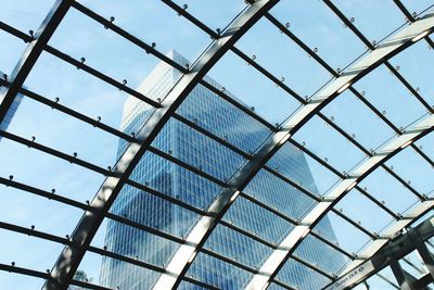 Low angle view of modern building seen through glass ceiling