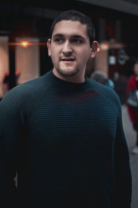 Close-up of young man looking away standing outdoors