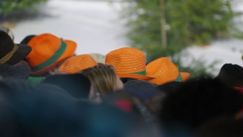 Close-up of orange hats wearing during event