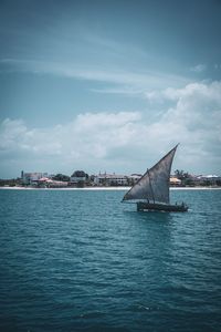 Sailboats in sea against sky