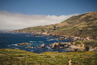 Scenic view of sea and mountains against sky