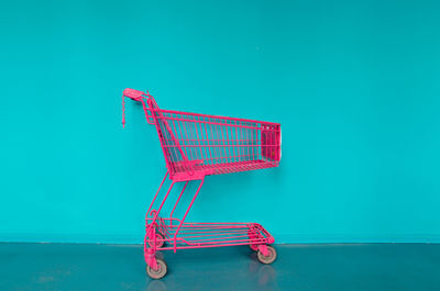 Shopping cart against blue wall