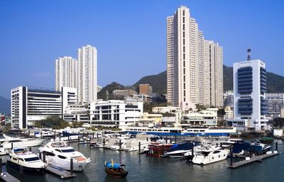 Boats in harbor with cityscape in background