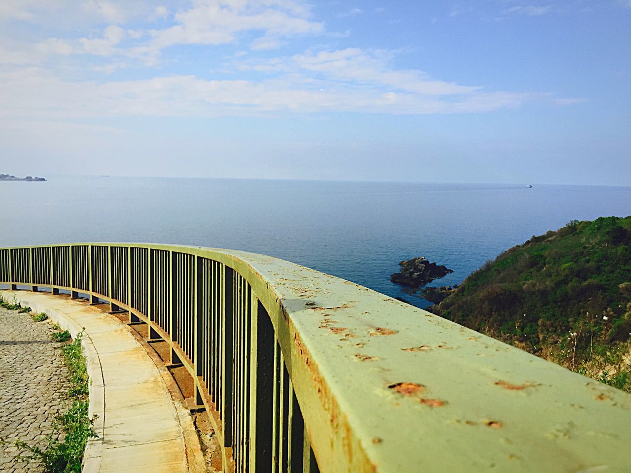 sea, horizon over water, water, beach, sky, tranquil scene, tranquility, shore, scenics, beauty in nature, sand, nature, idyllic, coastline, cloud - sky, railing, day, outdoors, high angle view, vacations