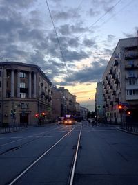 Road amidst buildings in city against sky